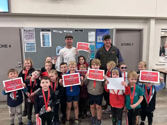 Dookie United Auskick presentation night — young players holding certificates and medals with their coaches